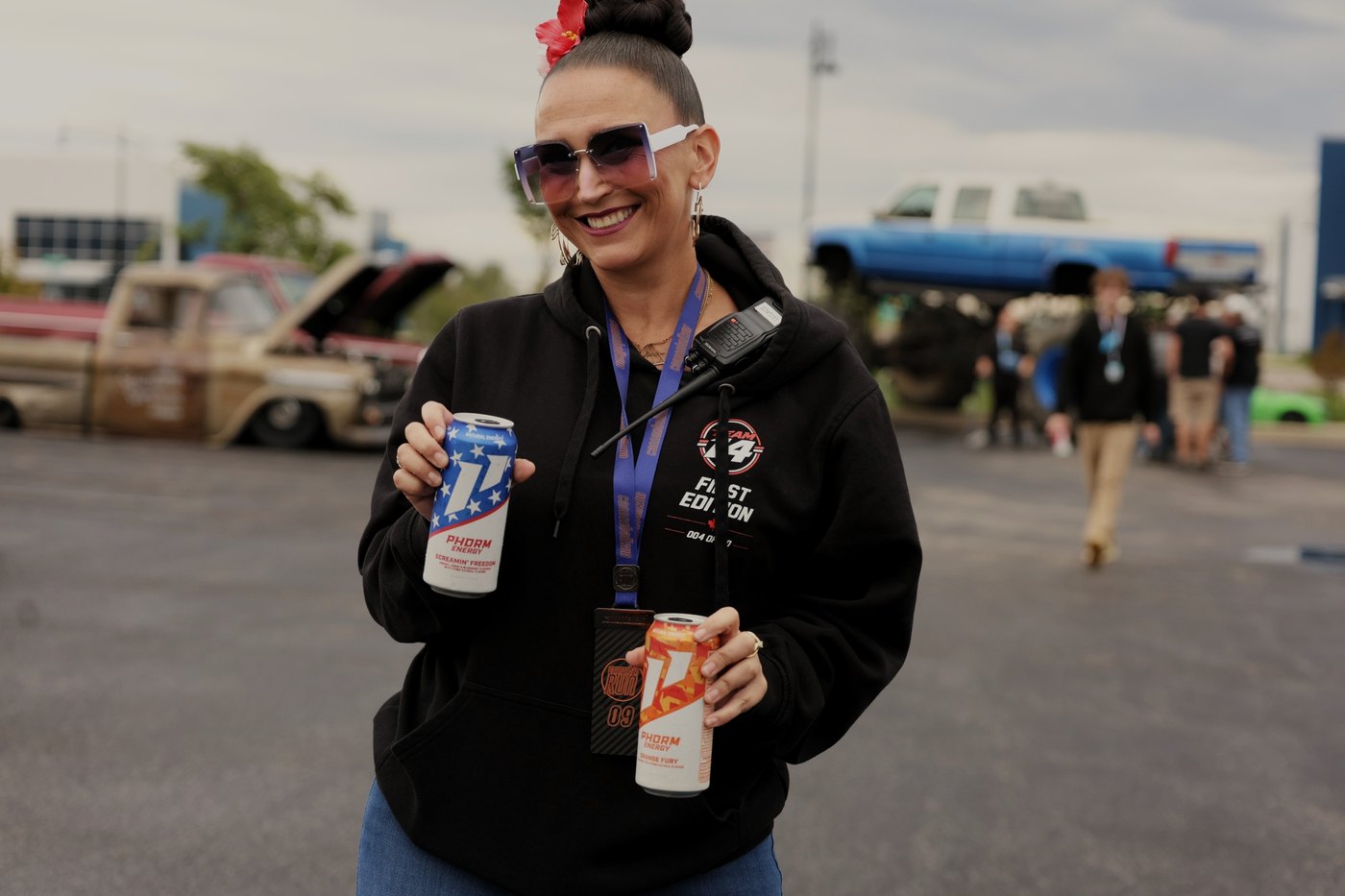 A Cannonball crew member grins, an energy drink in each hand