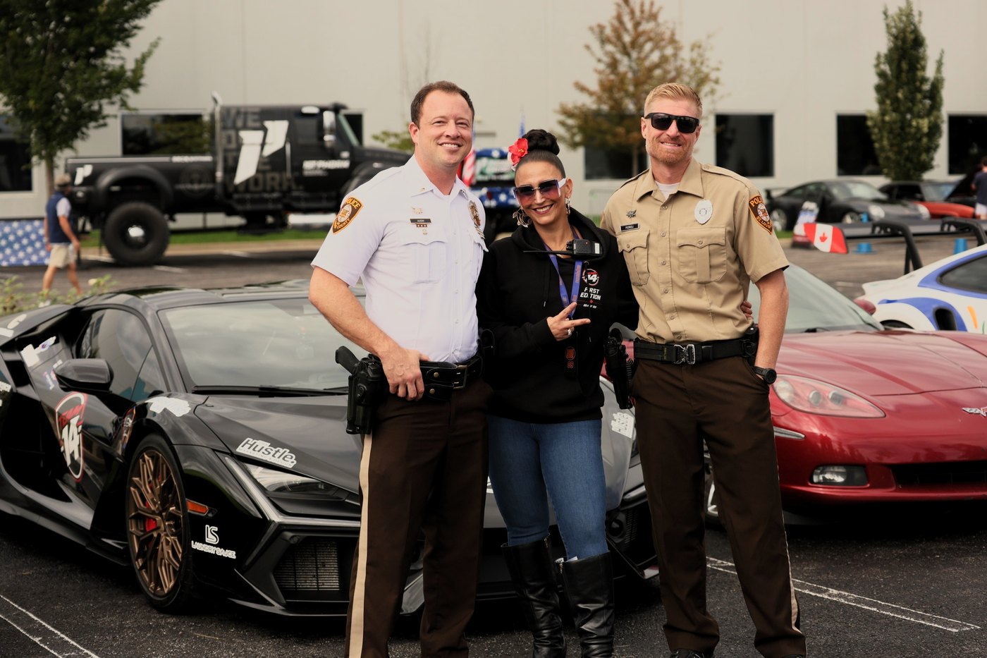 Two sheriff deputies pose with a driver and her Lamborghini