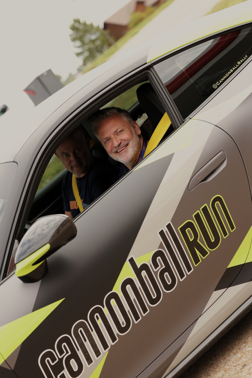 A driver looks out from behind the Cannonball livery on his door