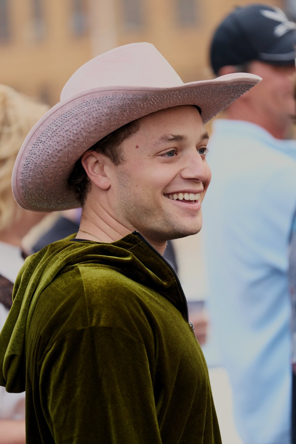 A driver in a cowboy hat laughs at the start